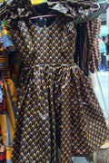 Traditional African print dress on a mannequin with beads in the background