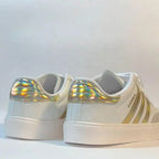 White sneakers with gold accents on a white background