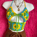 Mannequin wearing a colorful crochet top with a pink textured background