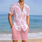 Person wearing a pink and white patterned shirt and pink shorts on a beach.