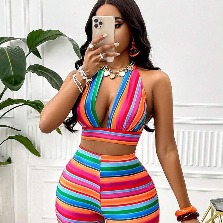 Woman taking a mirror selfie wearing a colorful striped outfit.
