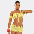 Woman wearing a yellow crochet two-piece swimsuit on a plain background