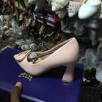 Display of various high-heeled shoes with a focus on a pink shoe on a blue stand.
