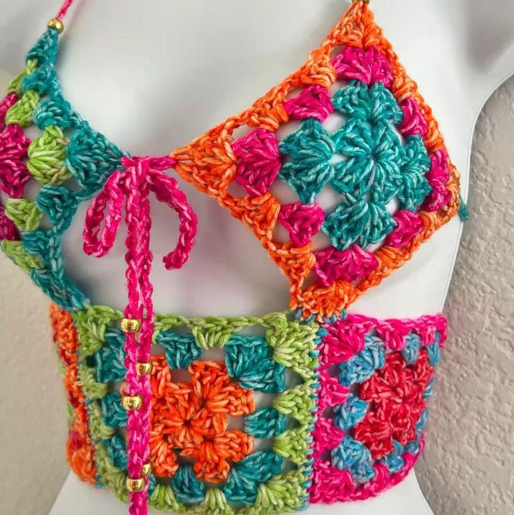Colorful crochet top on a mannequin against a neutral background