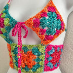Colorful crochet top on a mannequin against a neutral background