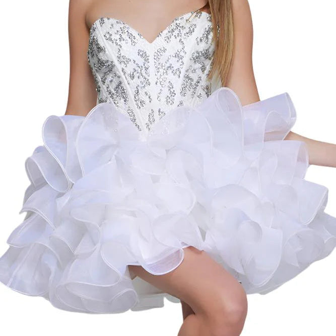 Woman wearing a white strapless dress with sequin bodice and ruffled skirt on a white background