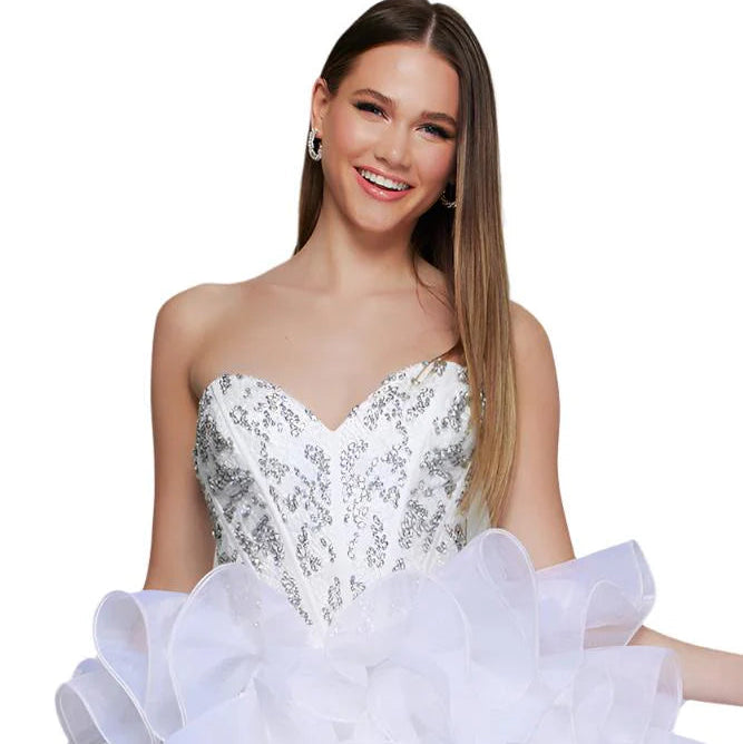 Woman wearing a white strapless dress with sequin bodice and ruffled skirt on a white background