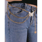 Gold chain belt with butterfly charm on blue jeans