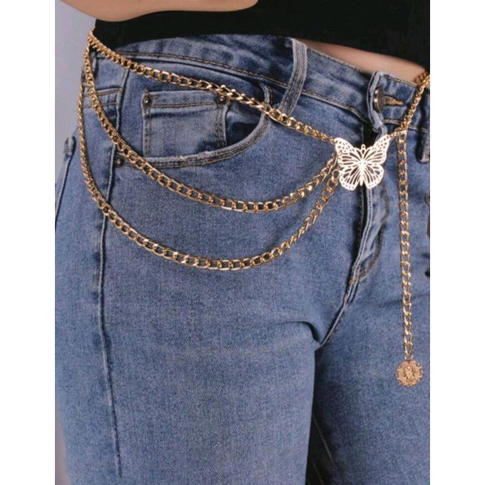 Gold chain belt with butterfly charm on blue jeans