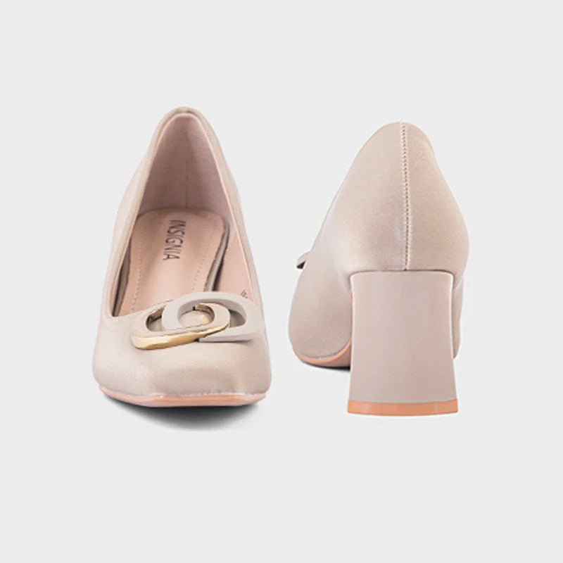 Pair of beige high-heeled shoes with a decorative buckle on a light gray background