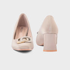 Pair of beige high-heeled shoes with a decorative buckle on a light gray background