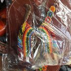 Colorful beaded rainbow keychain in clear packaging with brown leather background