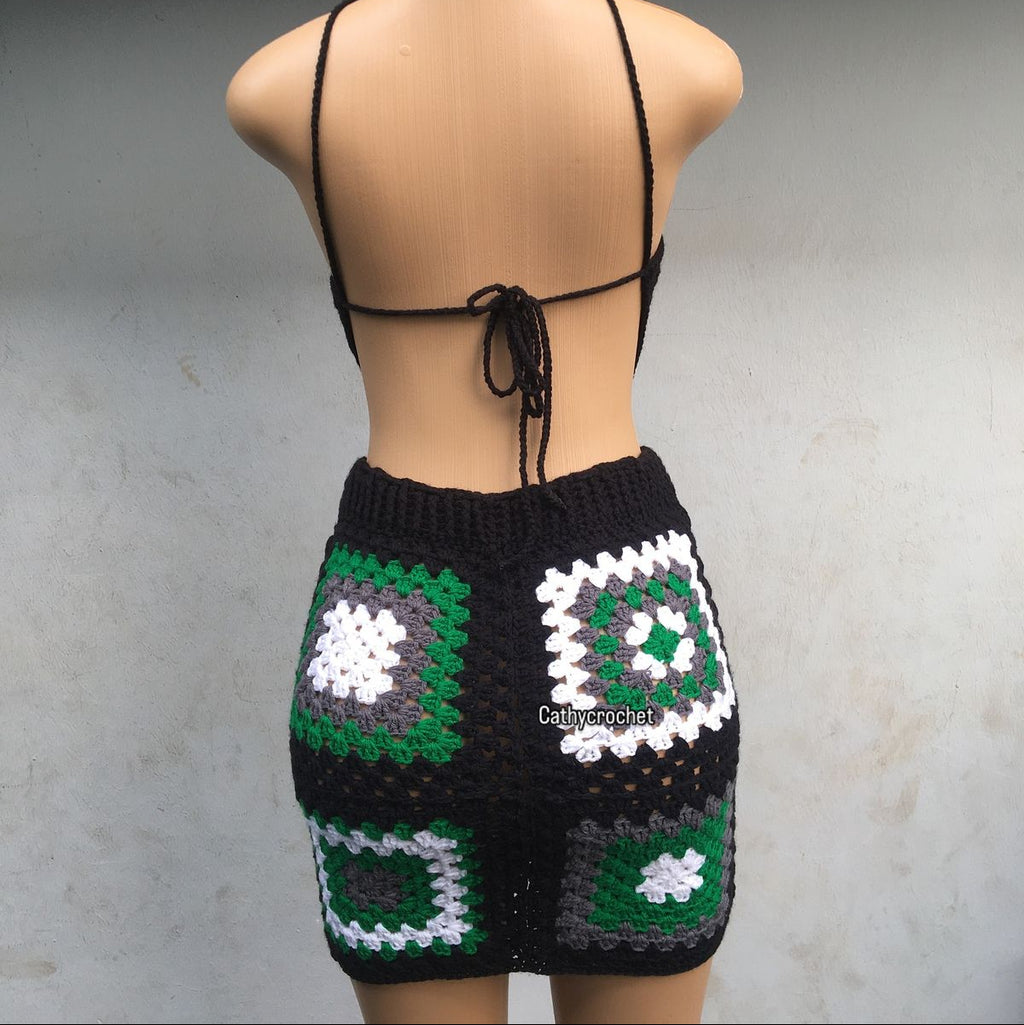 Mannequin wearing a black crochet top and shorts with geometric patterns on a gray background