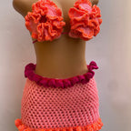 Crocheted bikini set with floral top and ruffled bottom on a mannequin against a plain background