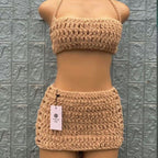 Crocheted beige bikini set on a mannequin against a textured gray wall.
