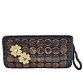 Woven clutch with circular patterns and floral embellishments on a white background