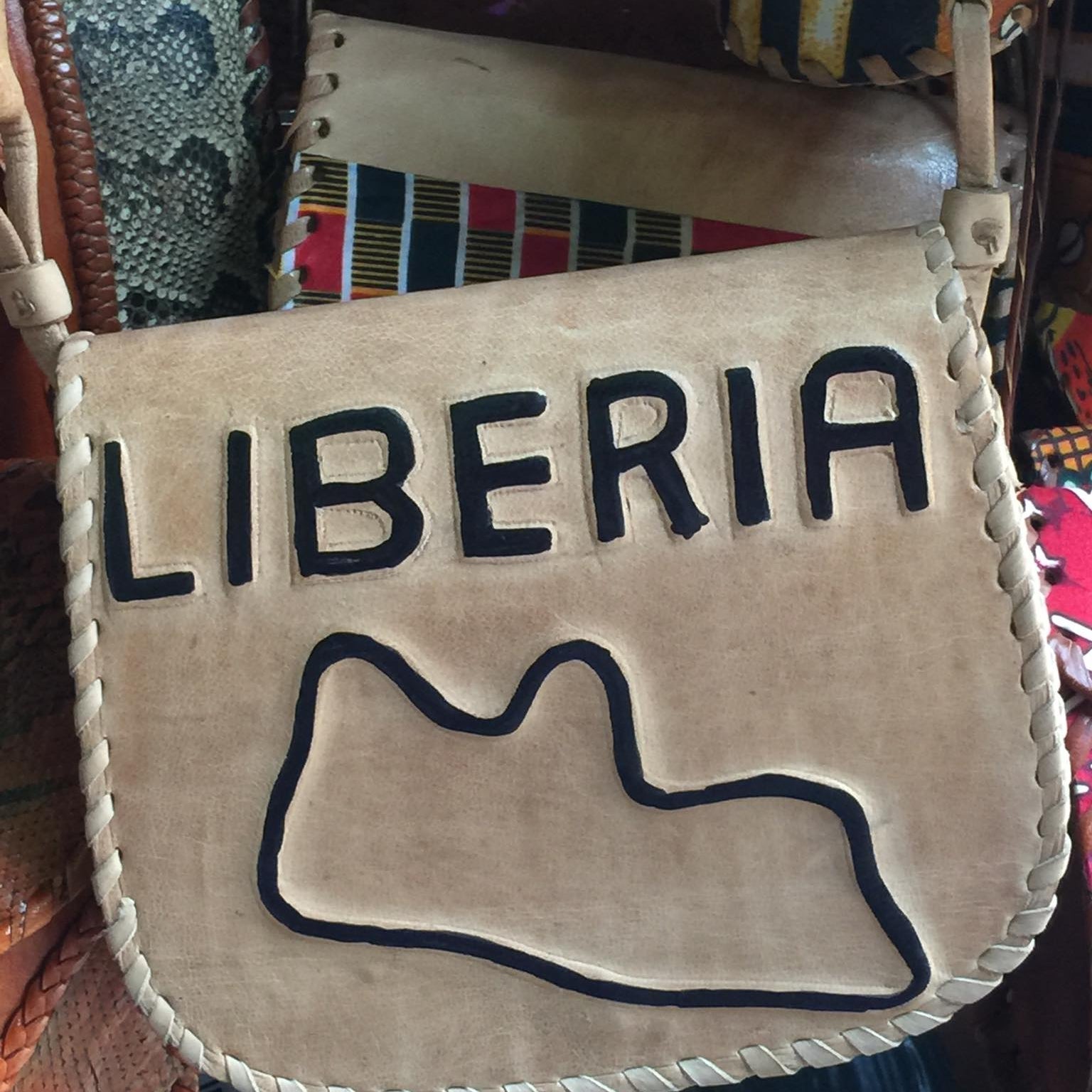 Leather bag with 'Liberia' and a map outline on a textured background