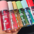 Set of colorful lip oil bottles held by a hand with text in the background.
