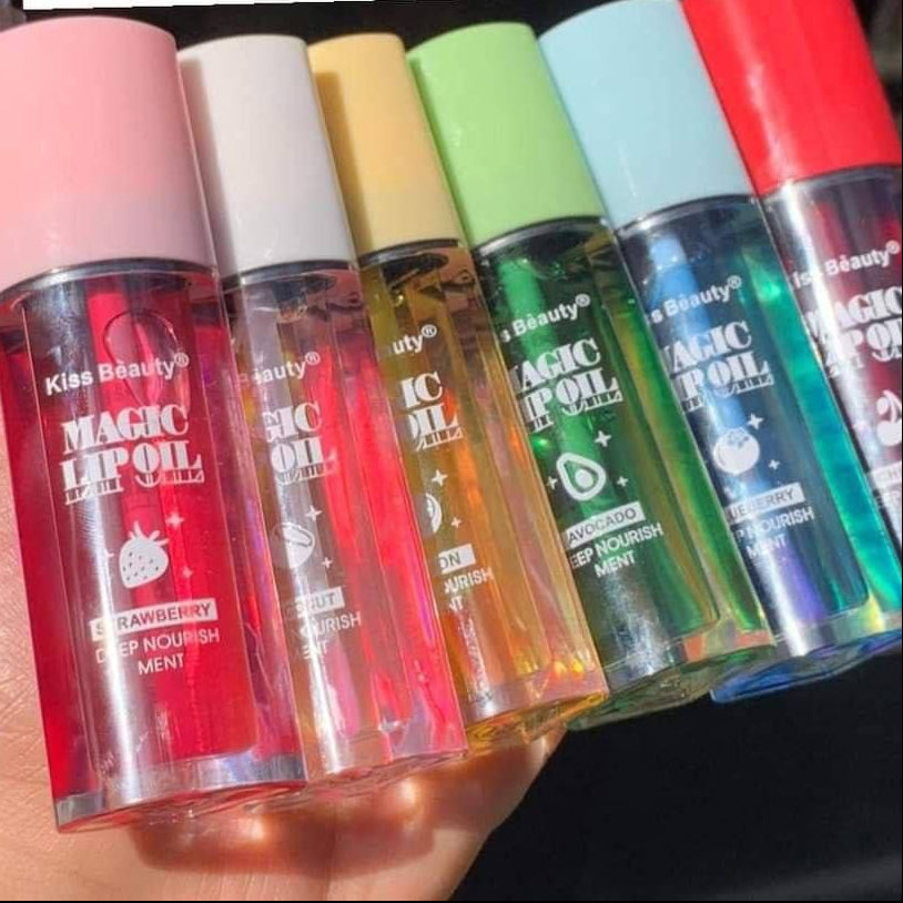 Set of colorful lip oil bottles held by a hand with text in the background.
