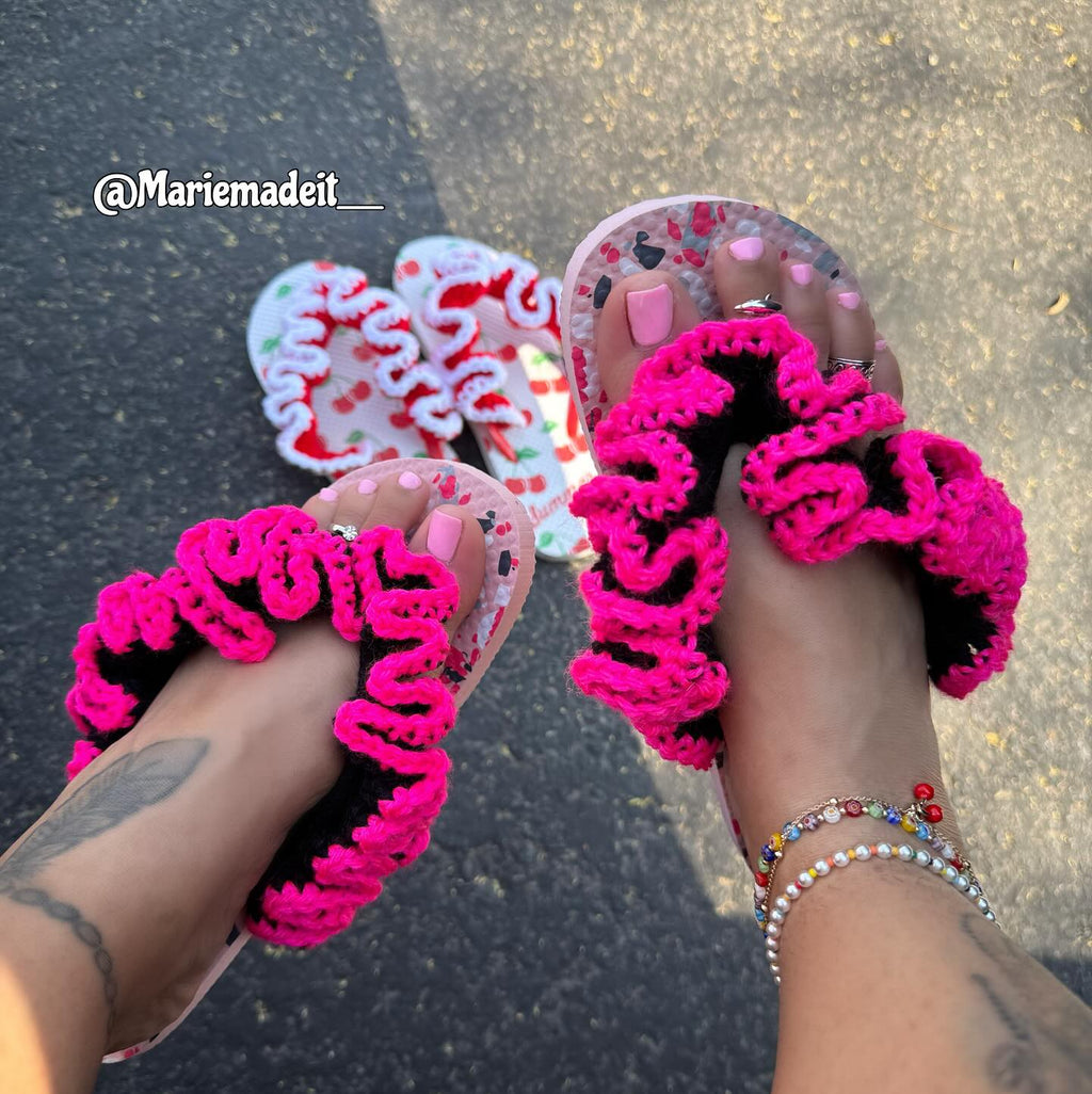 Pink crochet sandals worn on feet with a blurred background