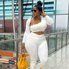 Woman in a white outfit with a yellow handbag walking in an indoor setting.