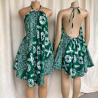 Green and white patterned dress on a mannequin against a white curtain background