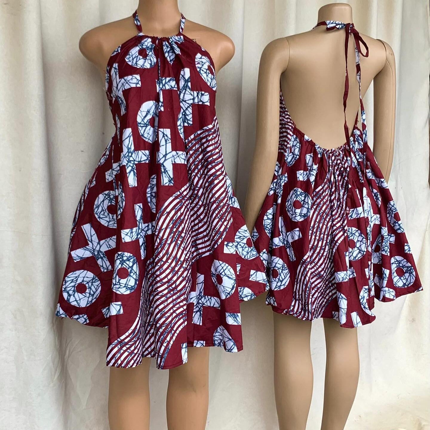 Red and white patterned dress on a mannequin against a plain background