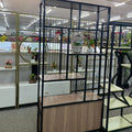 Room divider with glass panels and wooden base in a store setting
