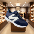 Navy blue sneaker with white accents held in a hand against a blurred natural background