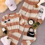 Striped sweater and pants set with accessories on a gray surface
