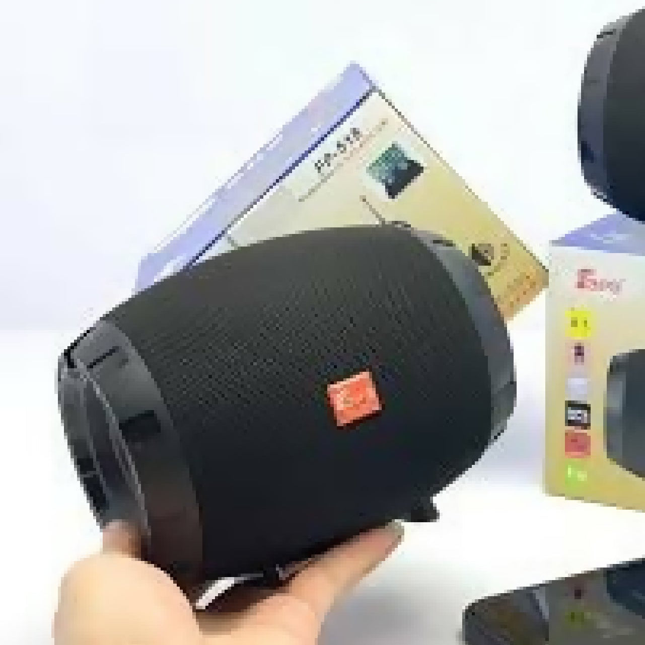 Black portable speaker with FP-518 model number, held in a hand, with a blurred background.