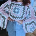 Woman wearing a colorful crochet sweater in an indoor setting