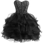 Black strapless dress with floral top and ruffled layers on a white background