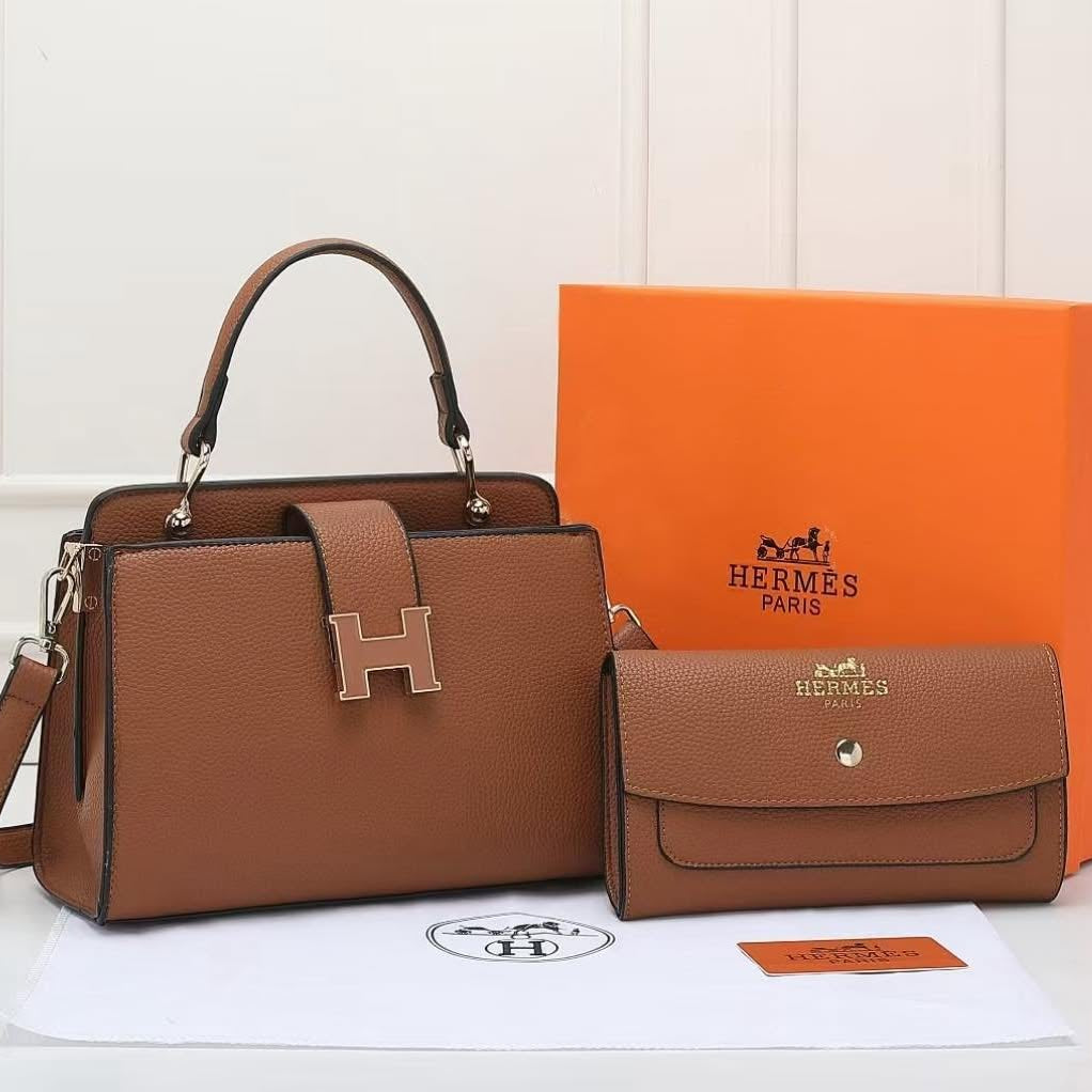 Brown handbag and matching wallet with Hermès packaging on a white background