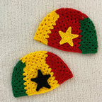 Two crocheted hats with Ghanaian flag colors and a star on a light gray background