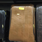 Brown leather suitcase with gold accents on a black background