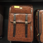 Brown leather suitcase with straps on a luggage rack