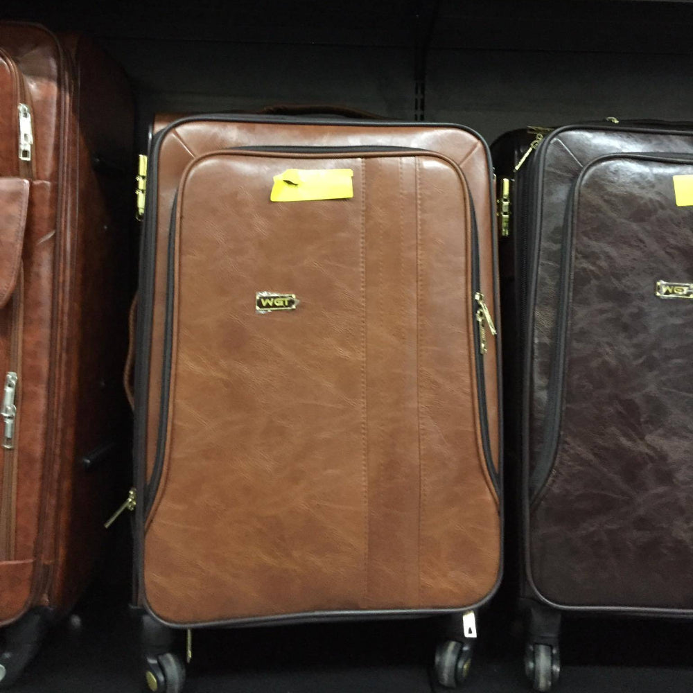 Brown and black suitcases with visible brand logos on a shelf.