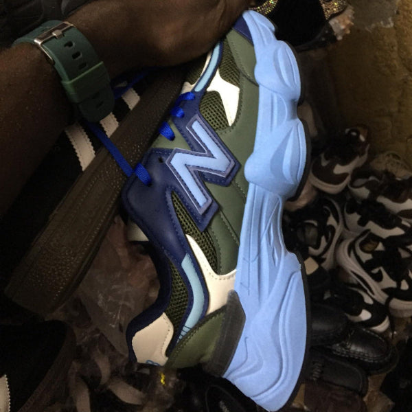 Person holding a green and blue sneaker with a prominent 'N' logo.