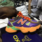Colorful sneaker with orange laces held by a hand in a shoe store.
