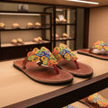 Pair of sandals with colorful beadwork on a blurred background
