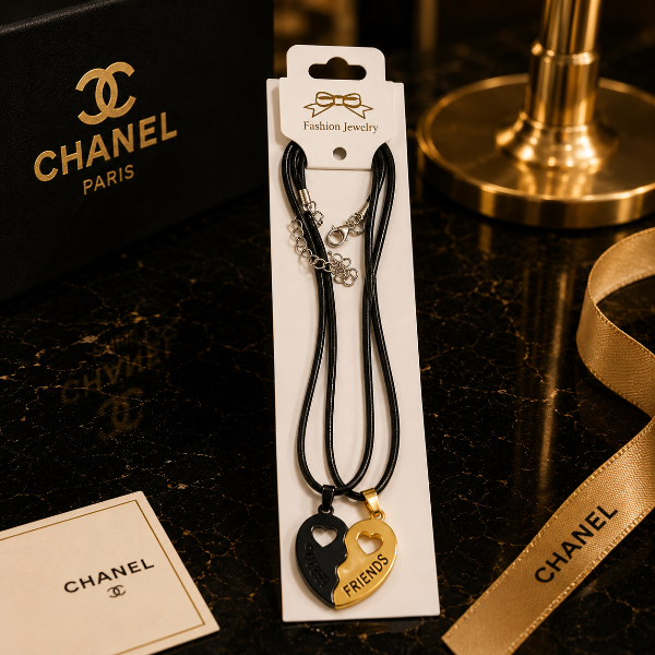 Chanel jewelry packaging with heart-shaped necklaces on a dark surface.