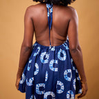 Person wearing a navy blue dress with white patterns on a beige background