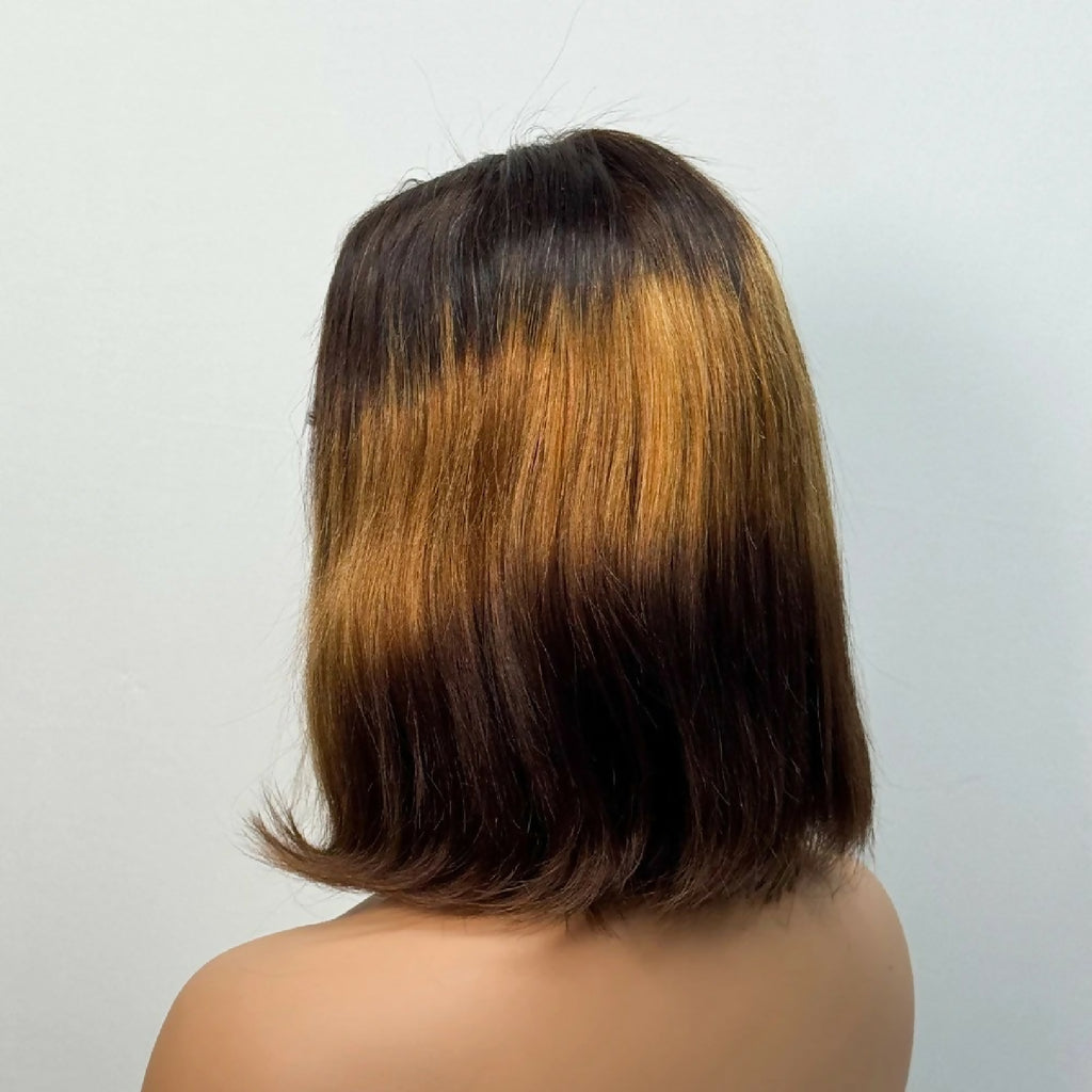 Back view of a person with a shoulder-length hair cut on a plain background