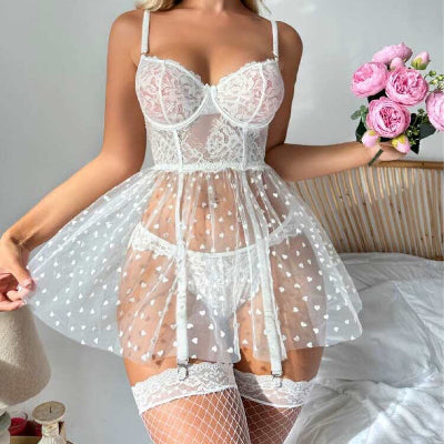 Woman wearing a white lace babydoll dress holding pink roses.