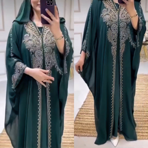 Green abaya with intricate silver embroidery worn by a person, displayed against a neutral background.