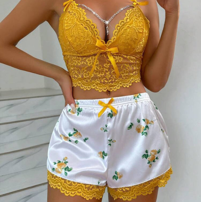 Yellow lace top and white shorts with floral embroidery on a neutral background