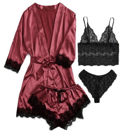 Red satin robe with black lace trim and matching bra and panties set on a white background