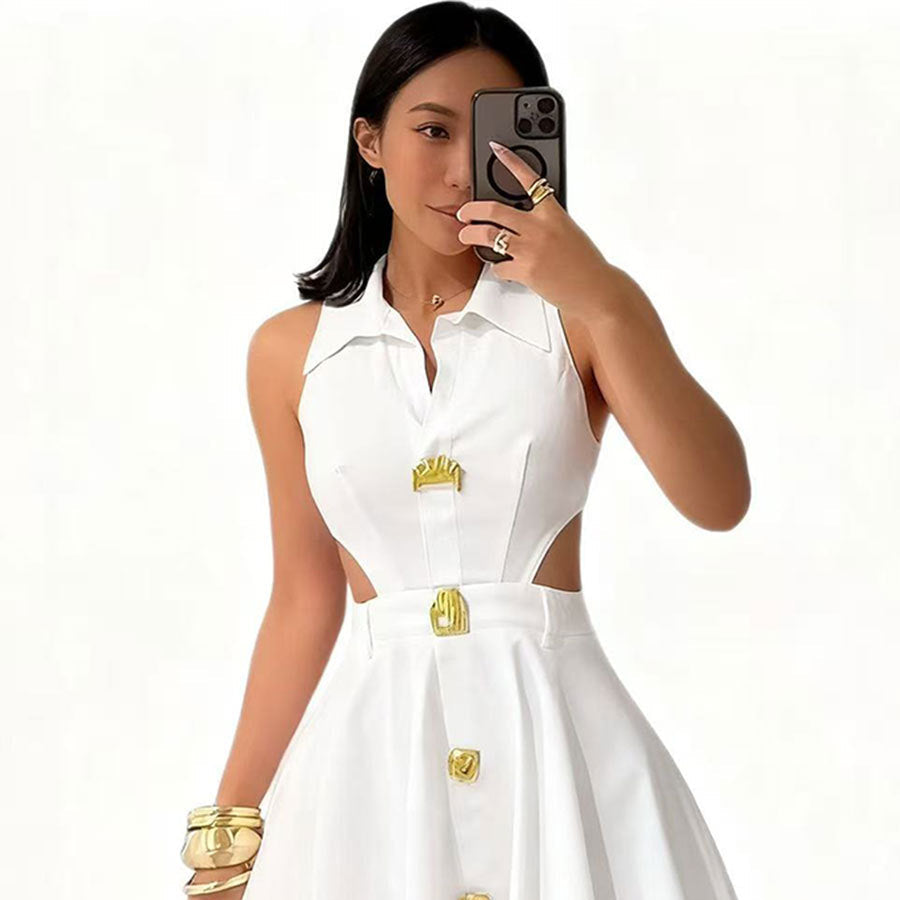 Woman wearing a white dress with gold accents, posing in front of a mirror.