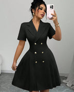 Woman wearing a black dress with buttons, taking a mirror selfie.